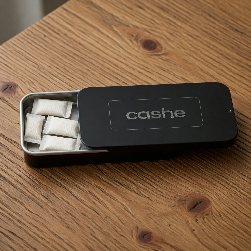 cashe tin open on a wood table with pouches in the tray